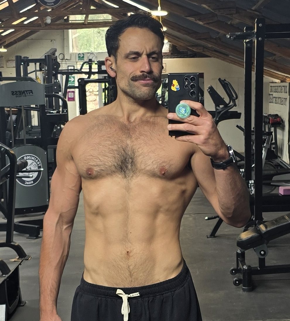 Sid in a gym mirror today, shirtless, moustache and a wry look
